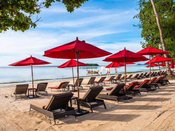 istock Lounge Chairs With Parasols At Beach Against Sky 1056999422