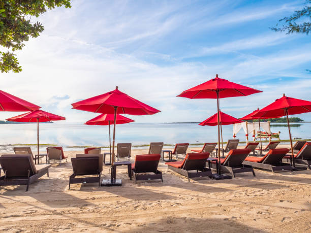 istock Lounge Chairs With Parasols At Beach Against Sky 1056999424