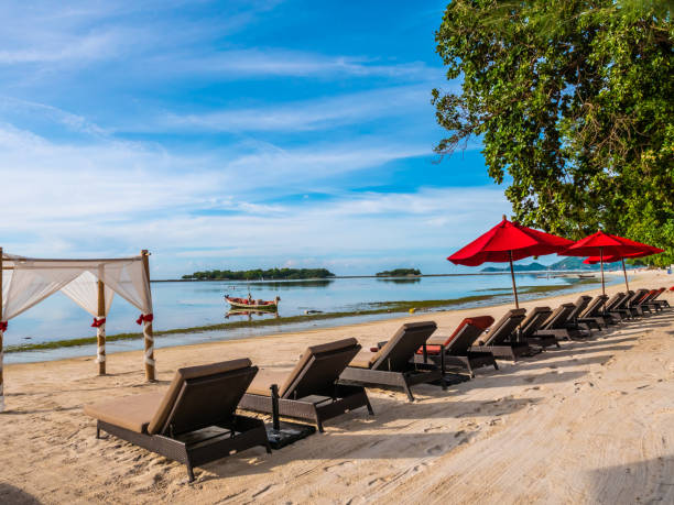 istock Lounge Chairs With Parasols At Beach Against Sky 1056999432