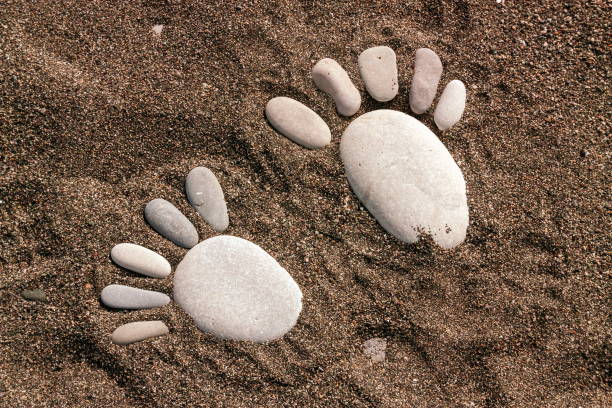 istock High Angle View Of Footprint Made With Pebbles At Beach 1057000588