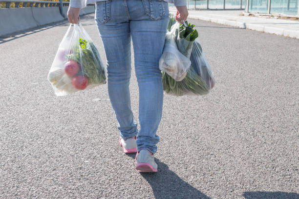 woman holding a plastic bag - tomato women green market imagens e fotografias de stock