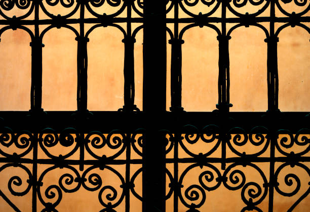 Ornate grate over window with terracotta wall background in Marrakesh, Morocco