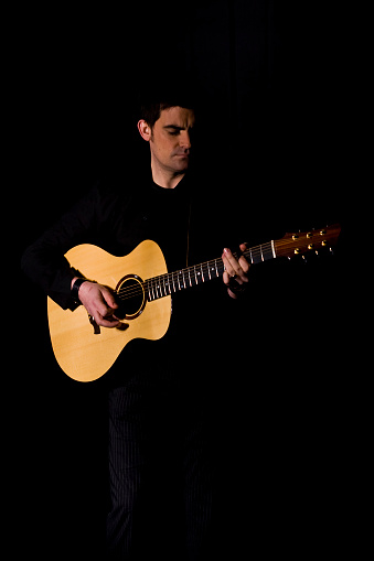 Man playing a guitar in the dark