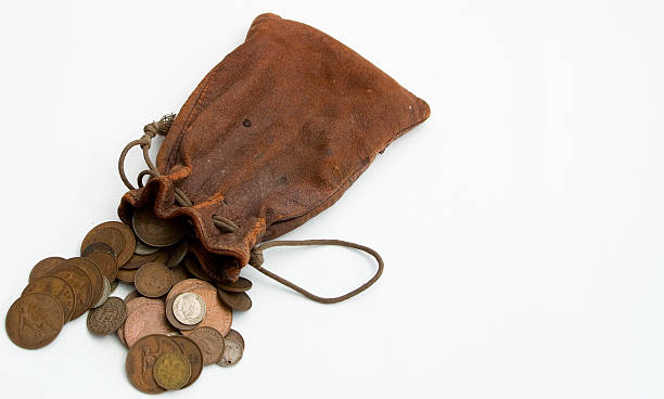 Worn leather purse spilling coins out onto white countertop A spilt purse of old coins anglo saxon photos stock pictures, royalty-free photos & images