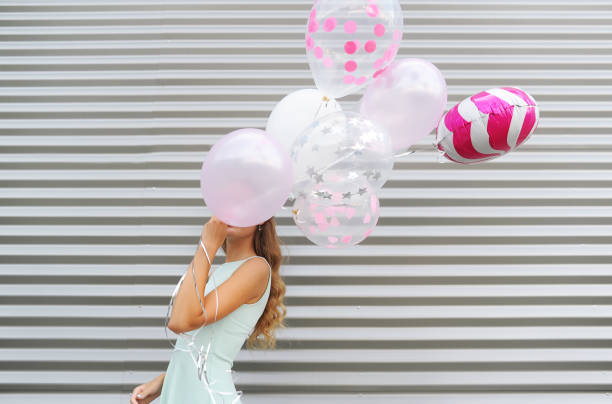 istock Young beautiful woman holding balloons and hiding behind them 1057030204