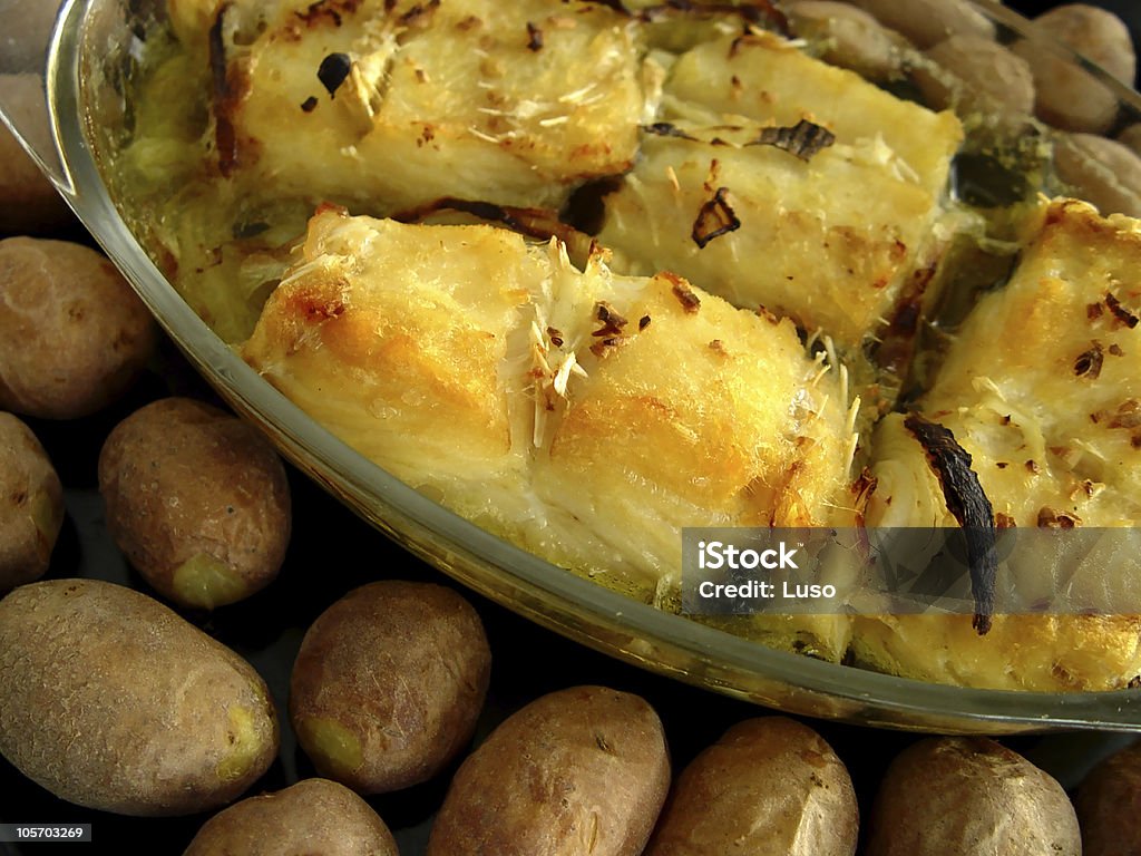 Codfish, Portuguese recepy Codfish, cooked in olive oil with baked patatoes on the side, (patatoes baked with peal, to be served "ao murro") traditional Portuguese Recepy. Baked Stock Photo