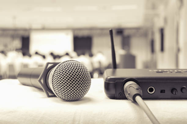 istock Close up old microphone wireless with box signal on the white table in business conference interior seminar meeting room and Background blur. Effects toning ancient 1057042262
