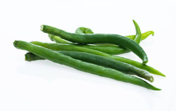 istock Green chili peppers on white background 1057059080