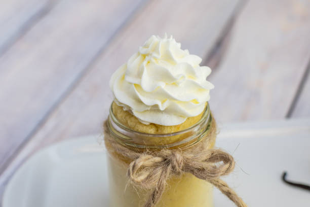 Baked custard made from egg yolks in jar with whipped cream stock photo
