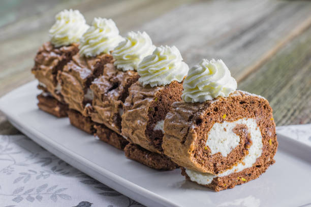 Five pieces Chocolate roll filled with whipped cream on white tray stock photo