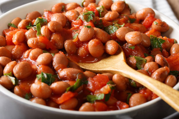 istock Cranberry beans in tomato sauce with herbs close-up in a bowl. horizontal 1057063320