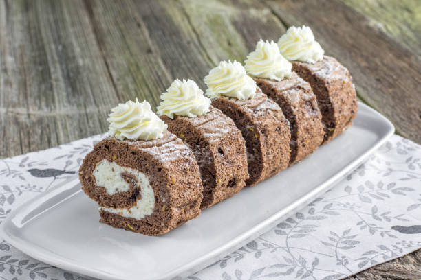 Five pieces Chocolate roulade filled with whipped cream on white tray stock photo