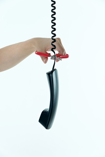 Woman hand using scissors to cutting telephone line.