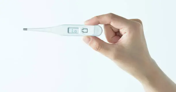 Photo of Woman hand holding a thermometer on white background