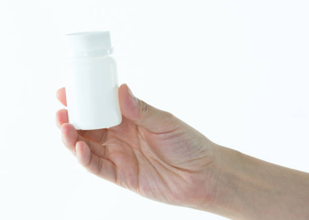 istock Woman hand holding a white pill bottle 1057067100