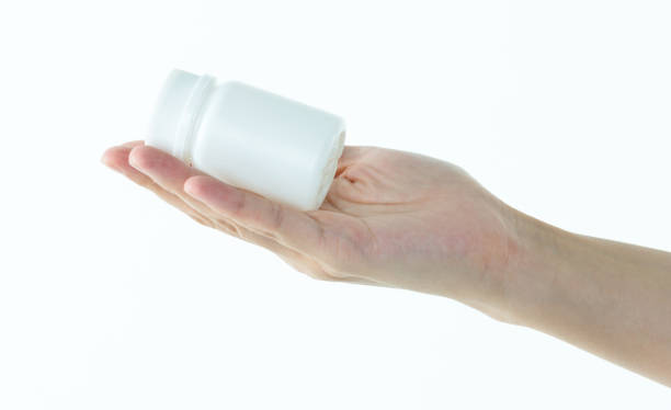 istock Woman hand holding a white pill bottle 1057067154