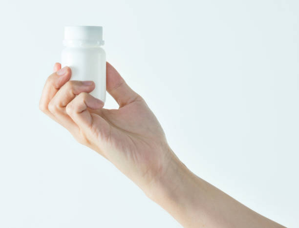 istock Woman hand holding a white pill bottle 1057067166