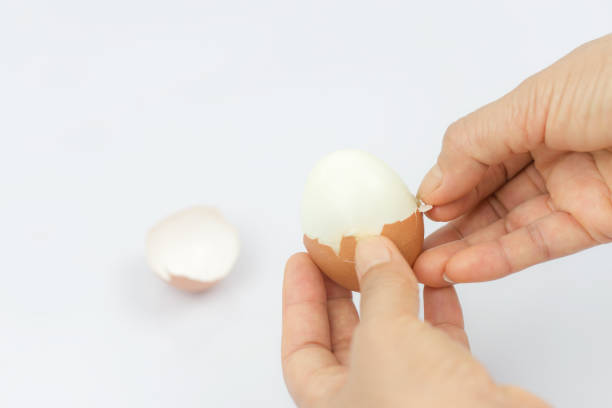 istock The girl is cleaning the egg with her hands White background 1057067746