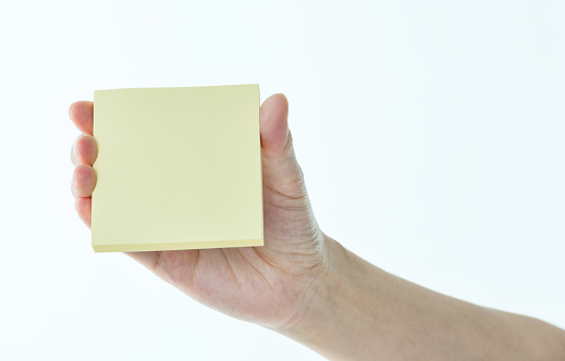 Woman hand holding sticky note on white background.