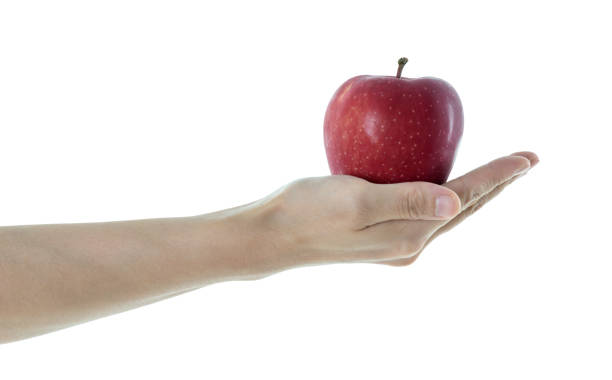 istock Woman hand holding red apple on white background 1057069286