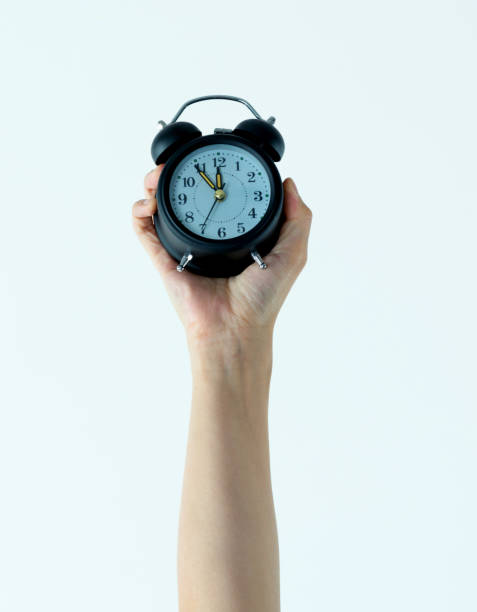 istock Woman hand holding alarm clock 1057069476
