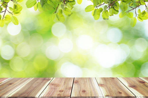 istock Empty wooden table with blurred city park on background The top has a natural  bokeh light,Mock up for display.  montage of product,Banner or header for advertise on social media,Spring and Summer. 1057071428