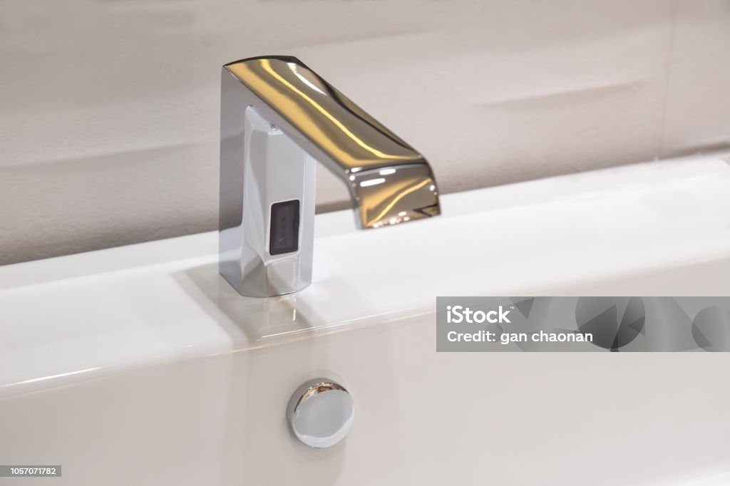Bathroom faucet in polished chrome powered automatic by sensor. object about home Improvement. Faucet Stock Photo