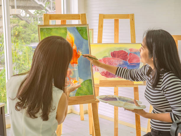 istock Two young asian woman artist dawning while useing ideas to think and create the best artwork together 1057072146