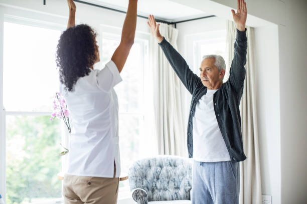istock Nurse and patient exercising with arms raised 1057076528