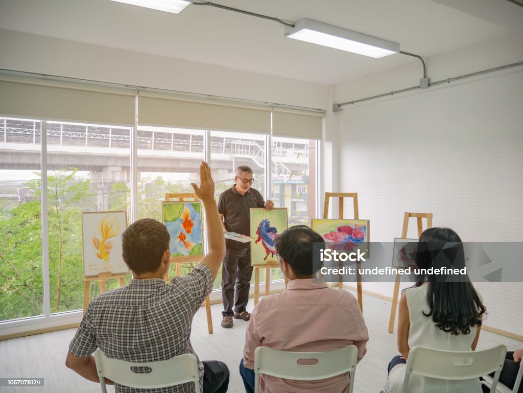 älteren Erwachsenen Künstler Lehrer Unterricht seines Schülers Hand Aufmachungen und Frage im Klassenzimmer - Lizenzfrei Aktenmappe Stock-Foto