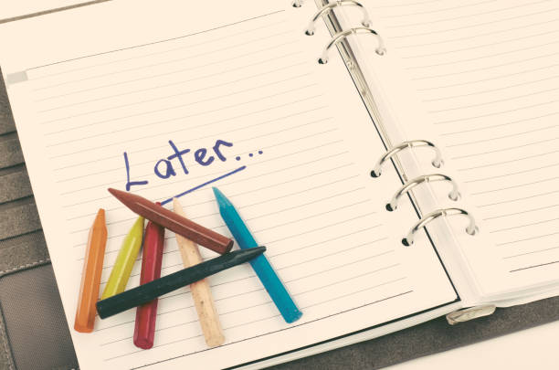istock procrastination and urgency concept with handwriting word Later on white book. 1057080230