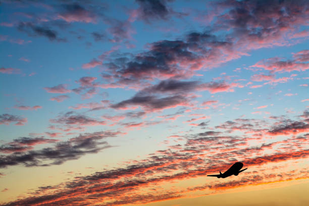 istock Colorful bright sunset with flying airplane silhouette 1057080782