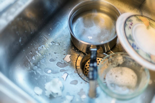 istock Broken Egg Shells and Soapy Hand Washed Dishes in a Stainless Steel Sink 1057082244