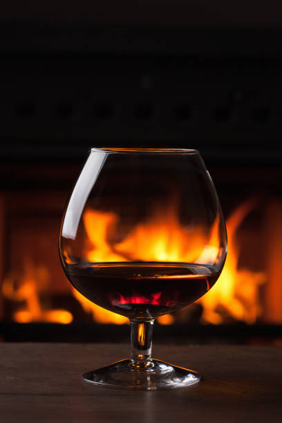 istock glass of cognac in front of fireplace 1057087866