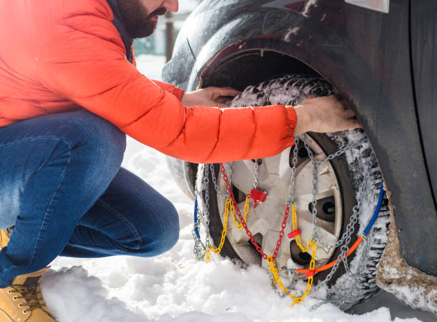uomo mettendo catene da neve su pneumatico auto - snow bound foto e immagini stock