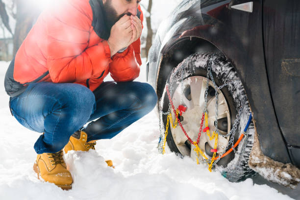 istock man putting snow chains on car tire 1057094768
