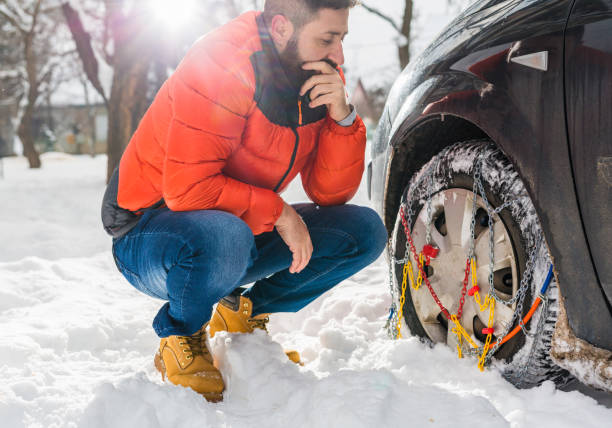 istock man putting snow chains on car tire 1057094874