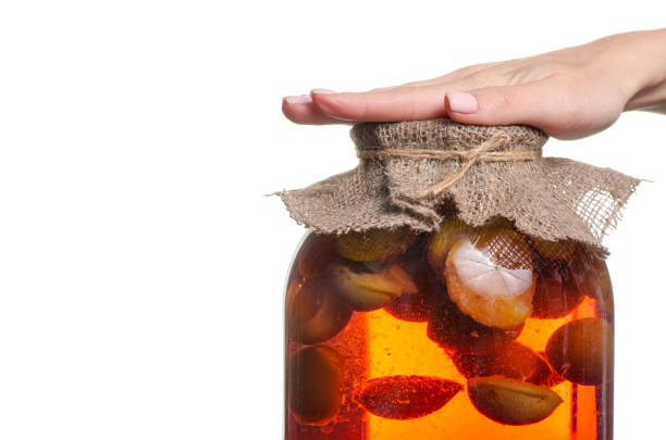 istock Compote pear apricot jar female hand 1057095678
