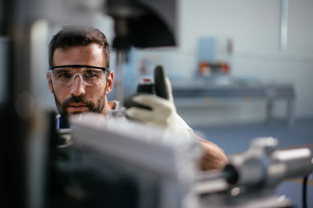 Worker in factory Worker in factory. Shadow DOF. Developed from RAW; retouched with special care and attention; Small amount of grain added for best final impression. 16 bit Adobe RGB color profile. protective eyewear stock pictures, royalty-free photos & images