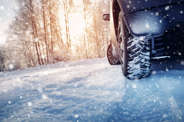 istock Car tires on winter road covered with snow 1057111038
