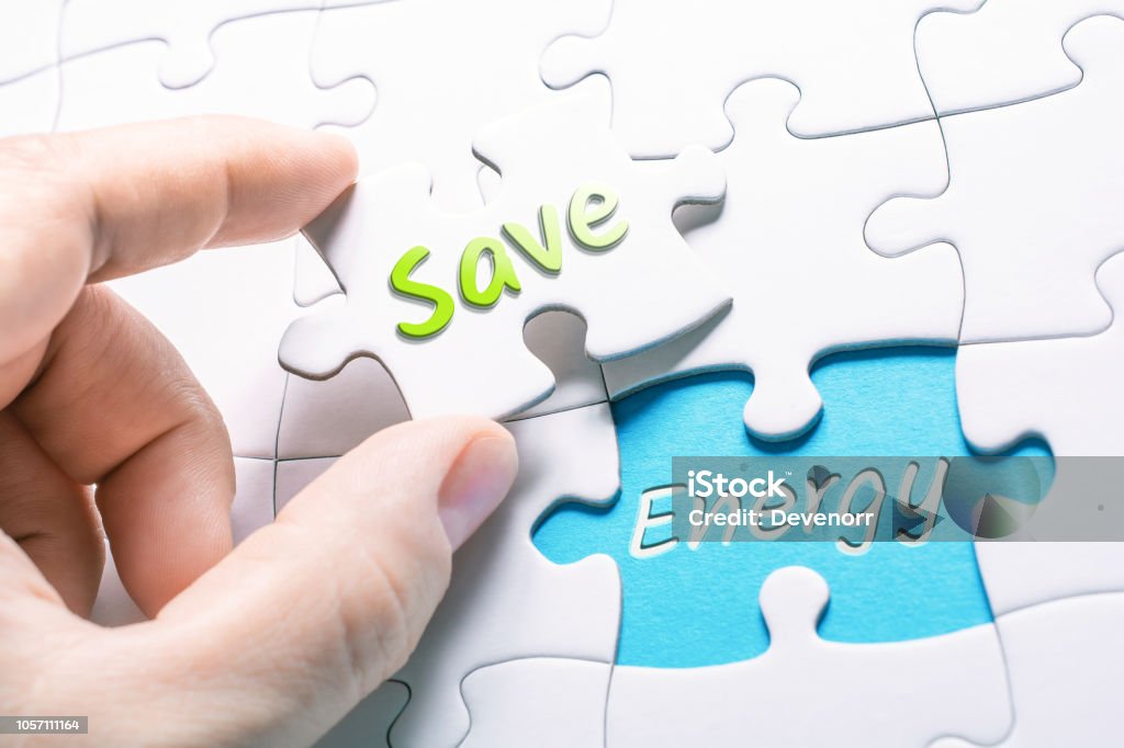 The Words Save And Energy In Missing Piece Jigsaw Puzzle The Words Save And Energy In A Missing Piece Jigsaw Puzzle Fuel and Power Generation Stock Photo