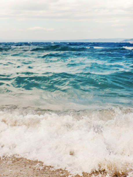 istock Wave of blue ocean on sandy beach Summer Background 1057111530