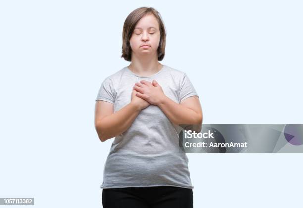 젊은 성인 여자와 웃 고 고립 된 배경 위에 다운 증후군 얼굴에 닫힌된 눈와 감사와 함께 가슴에 손 건강 개념입니다 감사에 대한 ... 젊은 성인 여자와 웃 고 고립 된 배경 위에 다운 증후군 얼굴에 닫힌된 눈와 감사와 함께 가슴에 손 건강 개념입니다 감사에 대한 ...