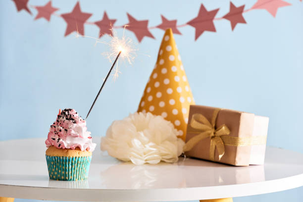 istock Birthday party background with cupcake, party hat and present 1057114400