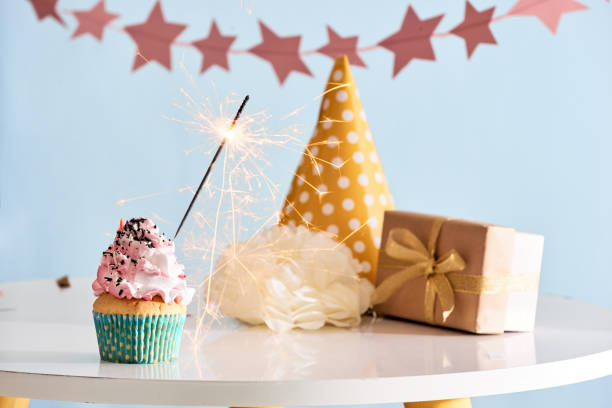 istock Birthday party background with cupcake, party hat and present 1057114428