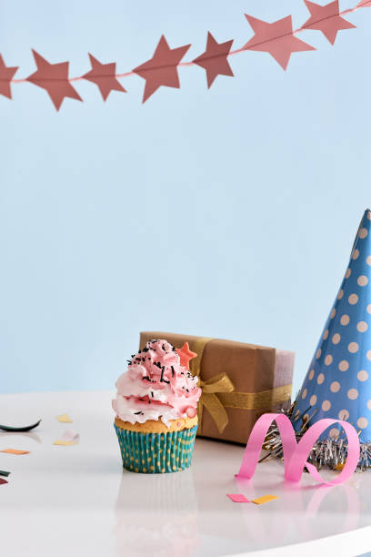 istock Birthday party background with cupcake, party hat and present 1057115492