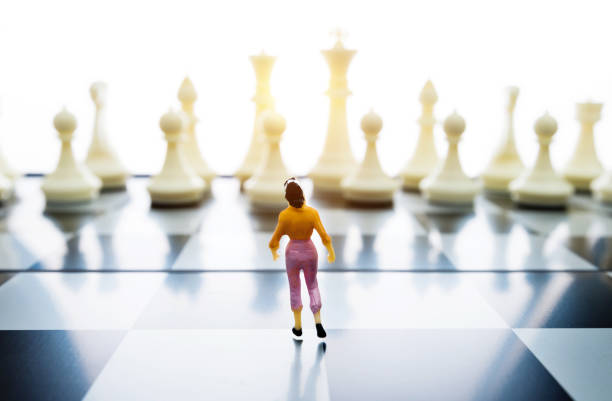 istock Woman figurine standing on a chessboard 1057116146
