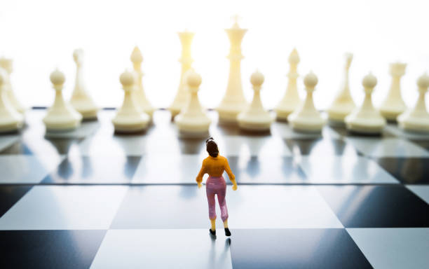 istock Woman figurine standing on a chessboard 1057116164