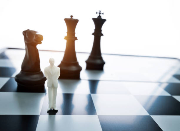 istock Man figurine standing on a chessboard 1057116256
