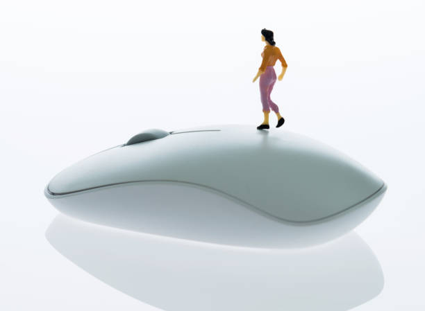 Woman figurine standing on computer mouse
